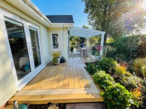 White pergola around a house providing overhead garden privacy