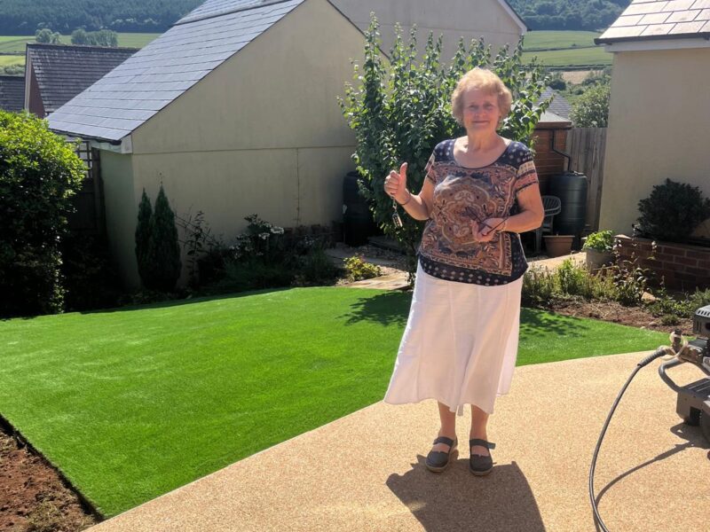 Happy customer in new garden with artificial grass