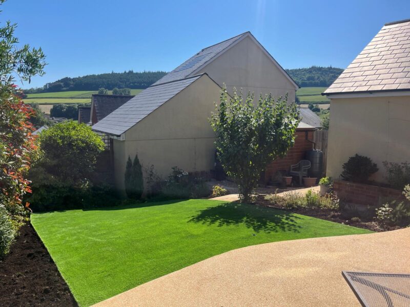 Artificial grass with resin patio and garden view