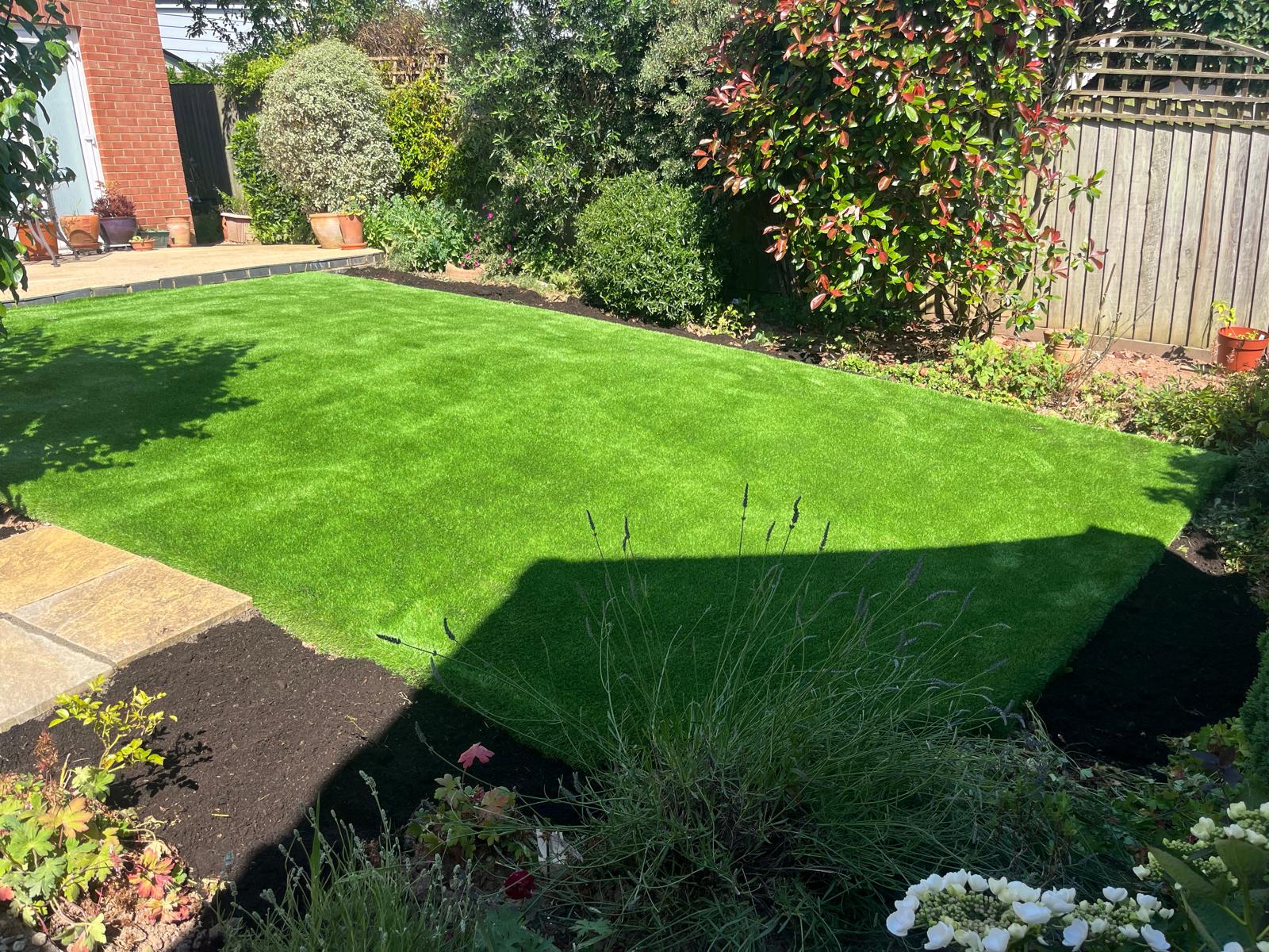 Residential back garden with artificial grass and landscaping
