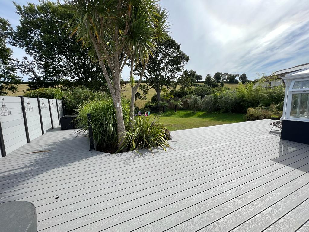 Wide view of grey composite decking and landscaped garden