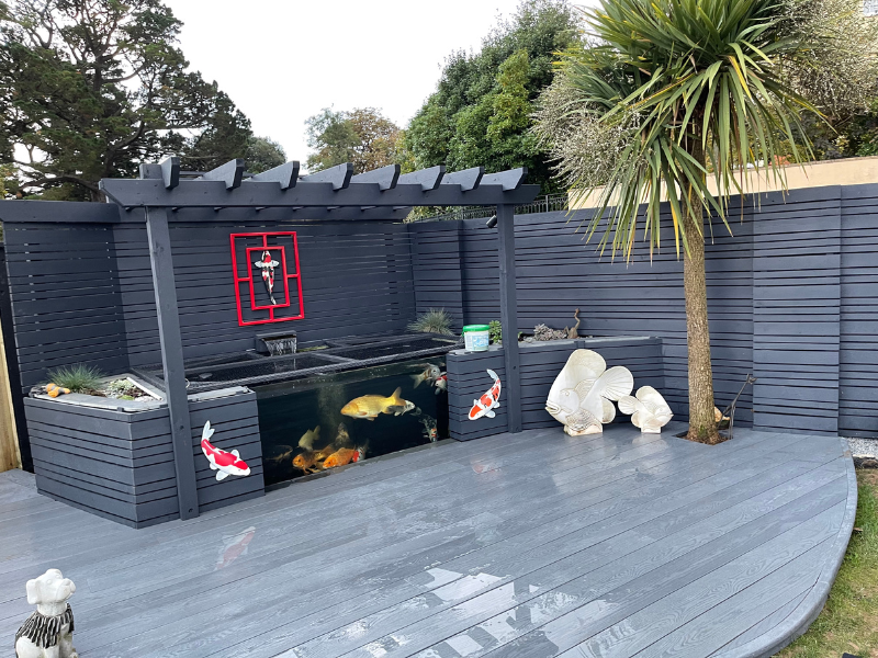 Decorative fencing and decking around garden fish pond