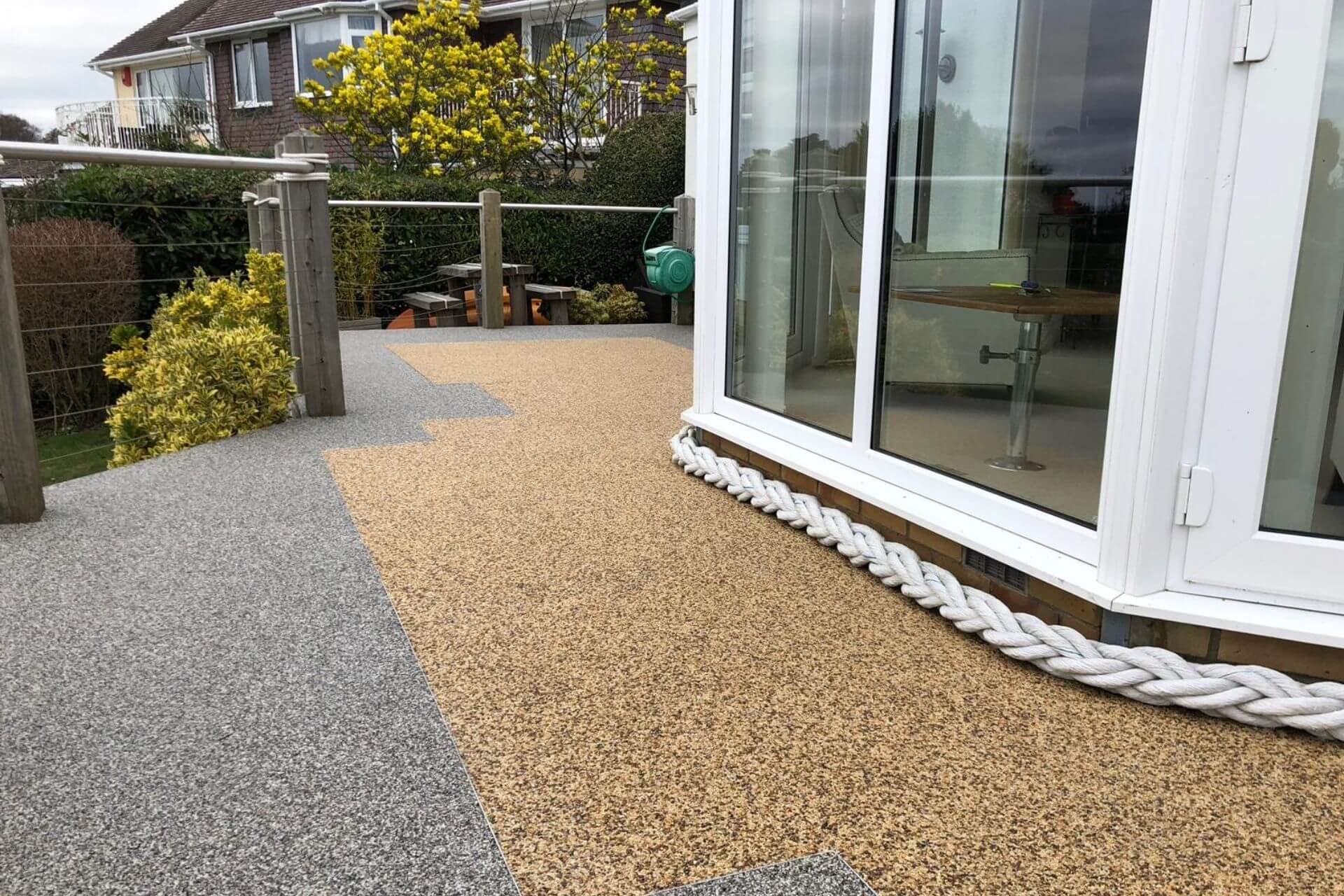Two-tone resin bound patio with golden and grey sections outside bifold doors