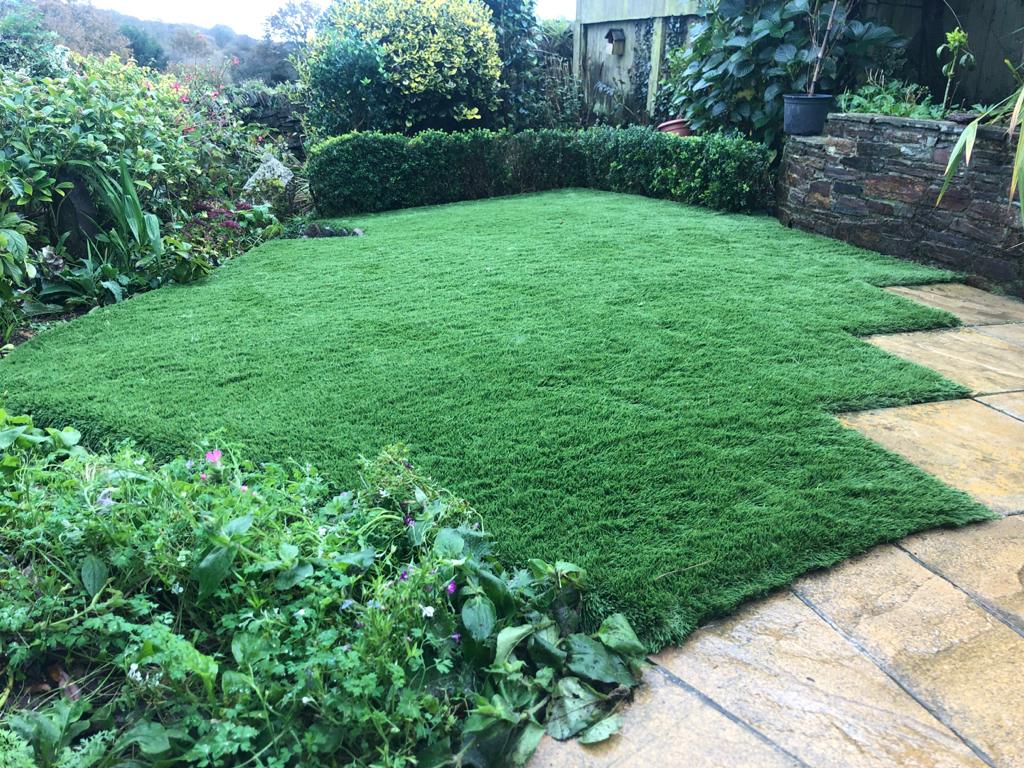 Artificial grass lawn installation in residential garden, Bodmin