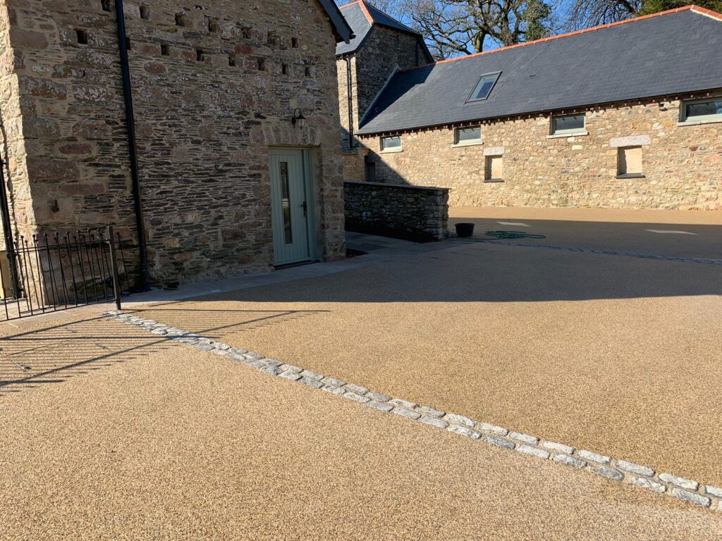 Resin bound surface with granite sett edging at barn conversion, Devon
