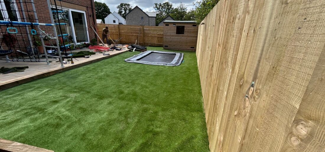Finished sensory garden with artificial grass, in ground trampoline and close board fencing
