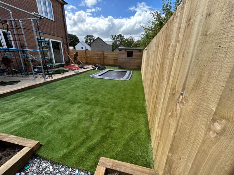 Finished sensory garden with artificial grass, in ground trampoline and close board fencing